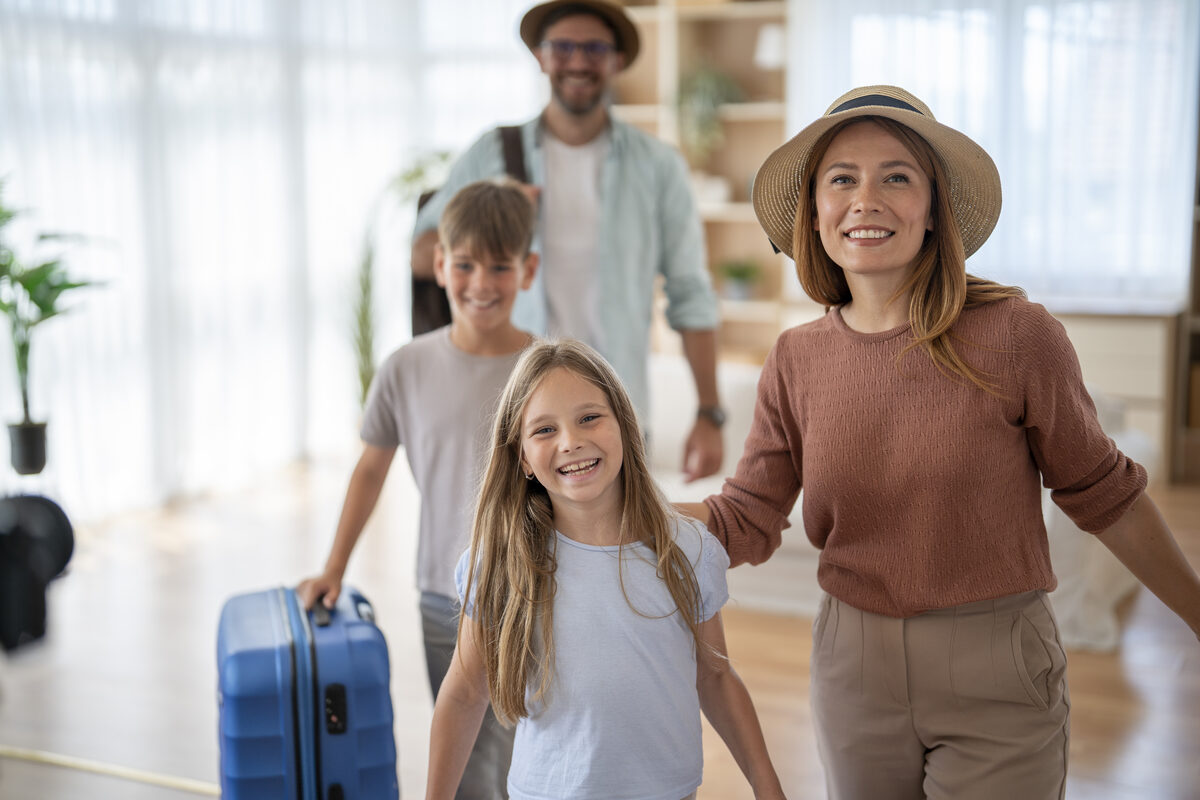 A family excitedly heading out on a trip with luggage